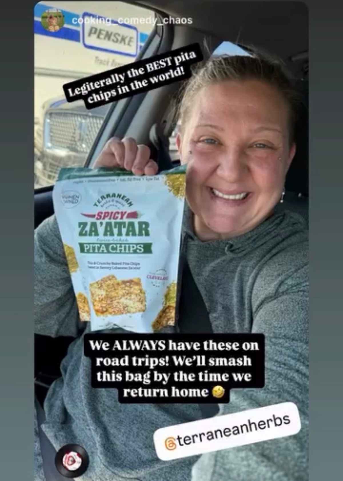 A woman in a gray hoodie smiles while holding a bag of Terranean Spicy Za'atar Pita Chips inside a car. The image includes social media style text overlays.